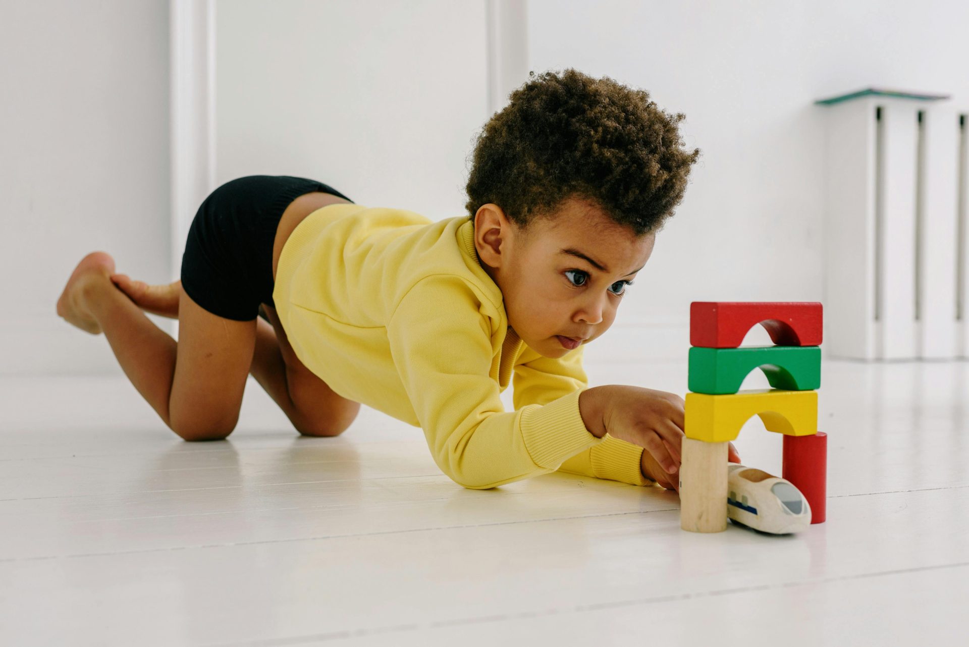 Young child playing with building blocks indoors, showcasing focus and creativity.