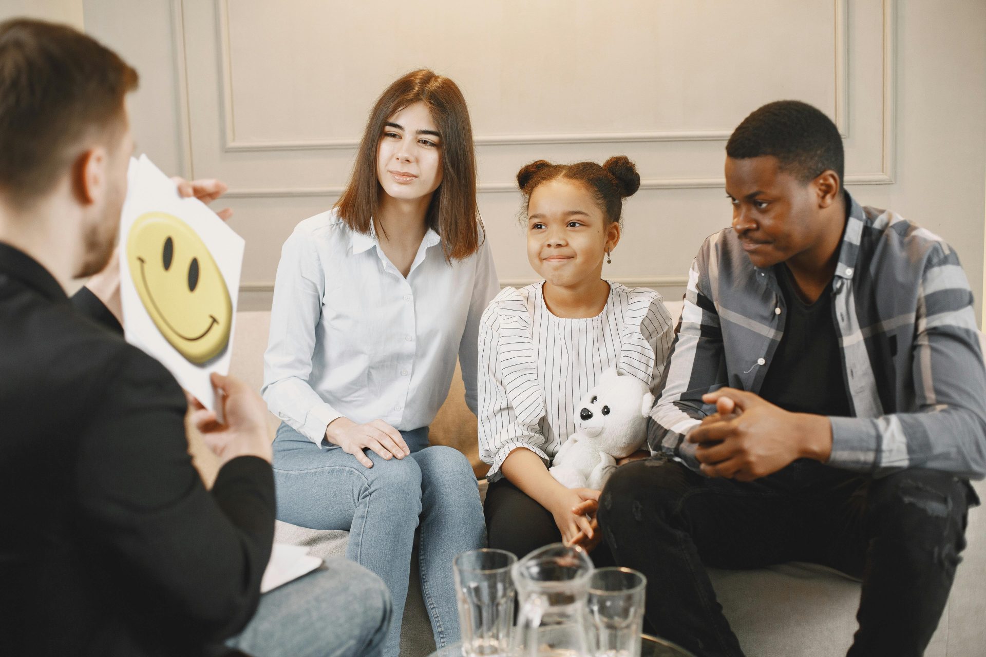 A family therapy session with a therapist, featuring parents and a child engaging in discussion.